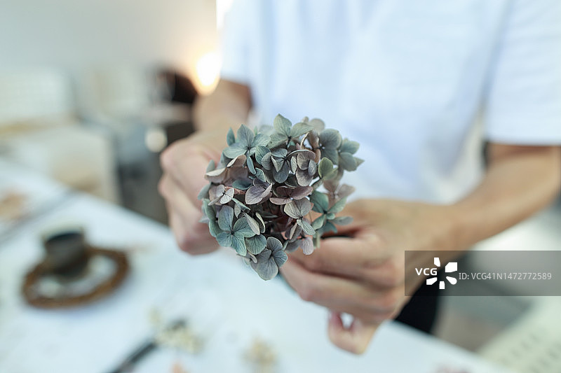 一名女花艺师正在制作一个绣球花花环图片素材