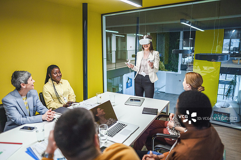 办公室会议中的商务人士展示和讨论虚拟现实技术图片素材