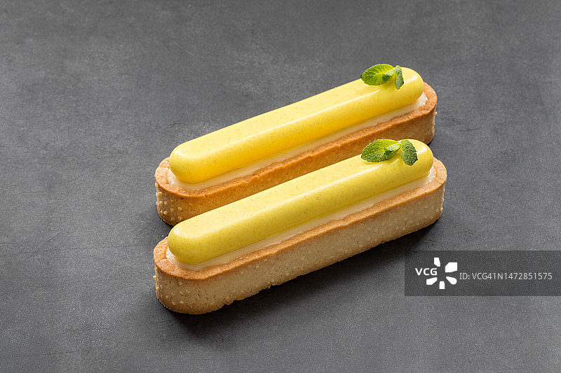 现代甜点：柠檬奶油挞与薄荷叶图片素材