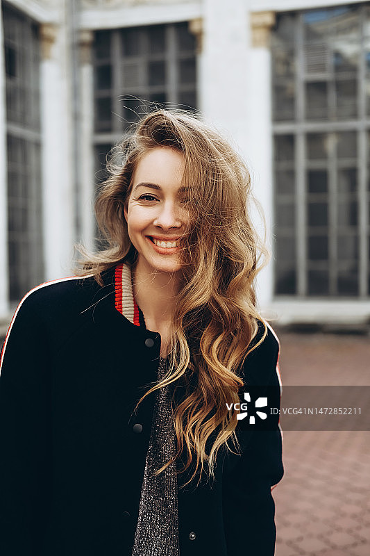 站在复古建筑前的快乐年轻女人图片素材