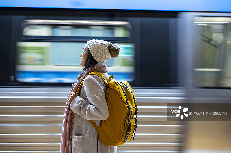 在城市地铁站使用手机的女人。城市地铁。图片素材