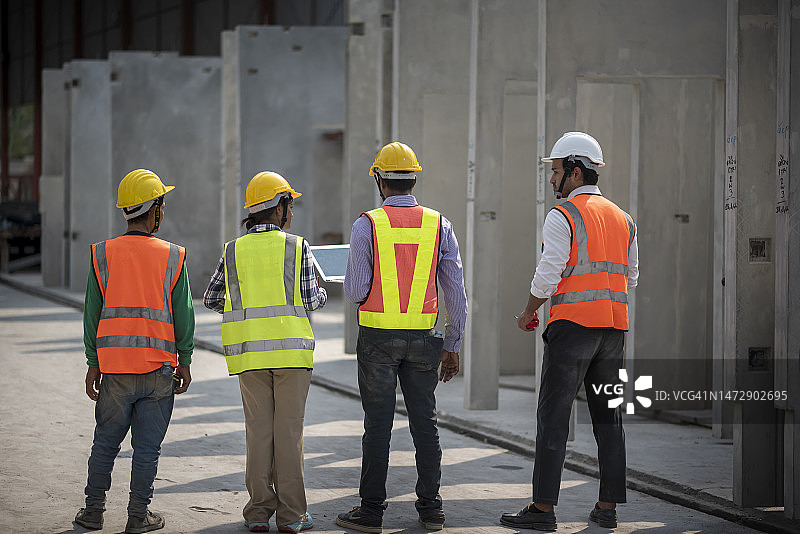 建筑工人在检查产品时进行讨论。图片素材