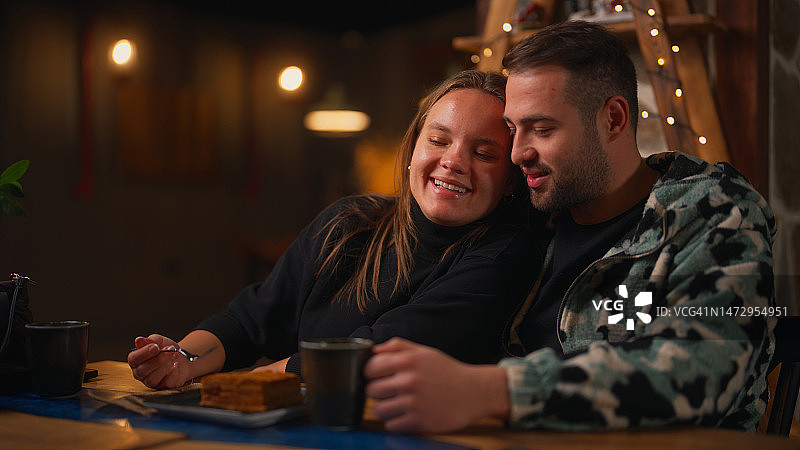 夜晚舒适咖啡馆里浪漫的年轻情侣图片素材