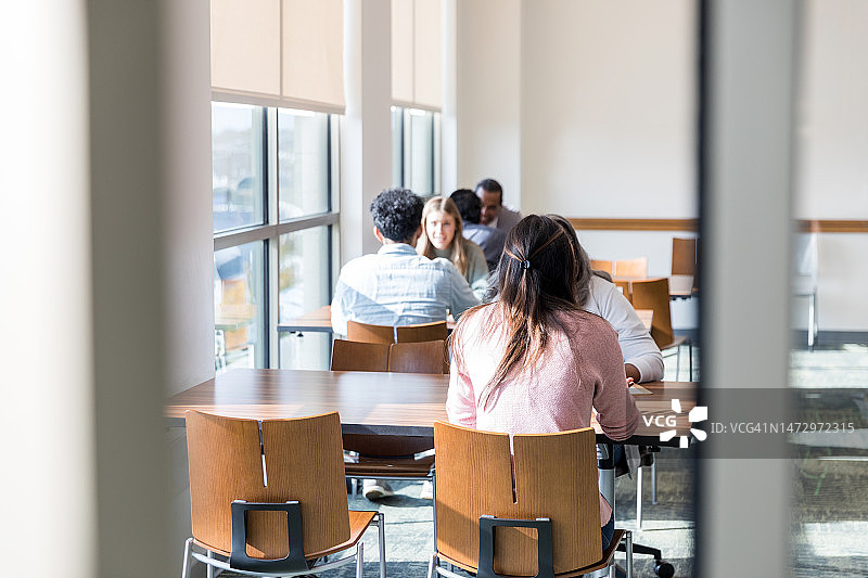 在会议室进行一对一讨论的多元化人群图片素材