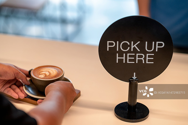 男性手部拿起咖啡拉花图片素材