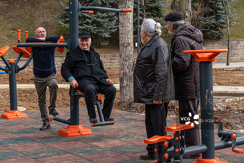 老年朋友们在公园和咖啡馆愉快地玩运动器材图片素材