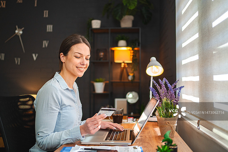 年轻女子用信用卡在线购物图片素材
