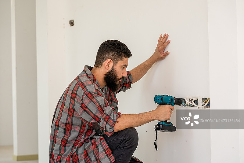 修理工使用无绳螺丝刀图片素材