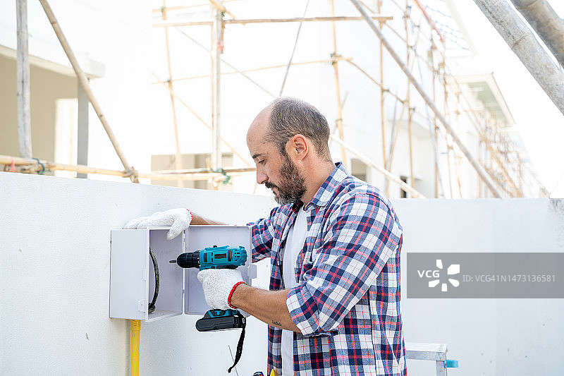 男人在房屋维修期间使用电钻图片素材