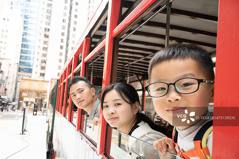 年轻父母带儿子乘坐香港电车图片素材