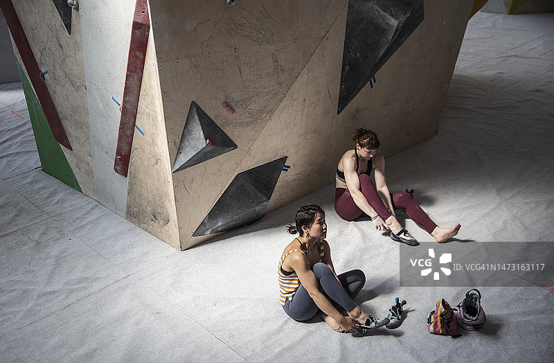 妇女在攀岩墙下穿鞋图片素材