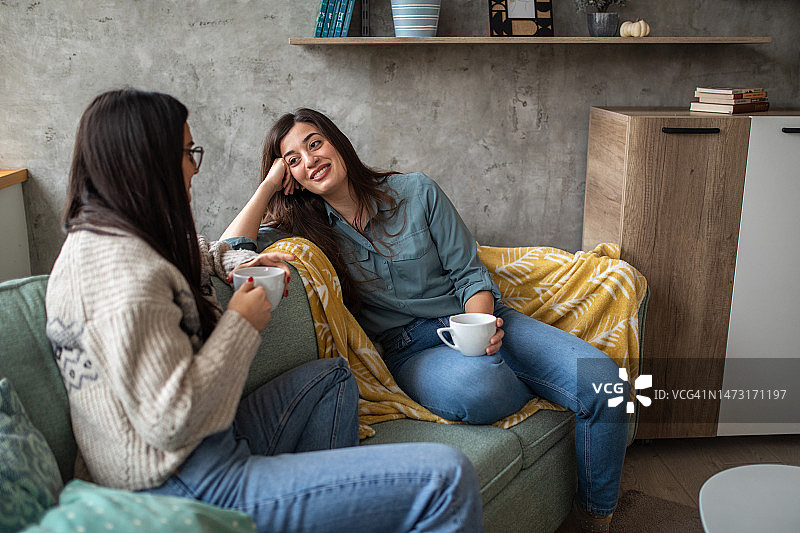 姐妹在客厅一起喝咖啡图片素材