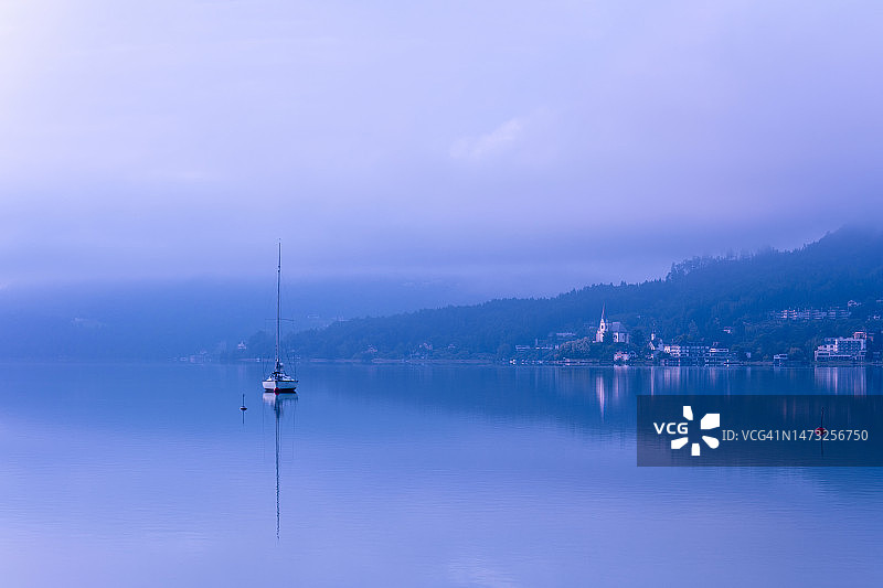 帆船、韦尔特湖的雾和日出时的山脉，克拉根福，奥地利，欧洲图片素材