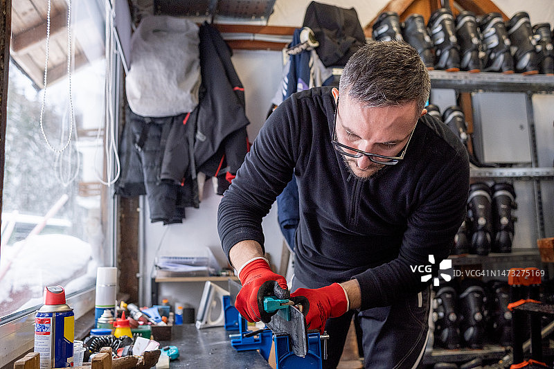 滑雪维护专家正在打磨滑雪板边缘图片素材