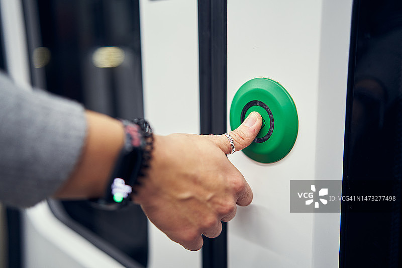 按下地铁门按钮的手指图片素材