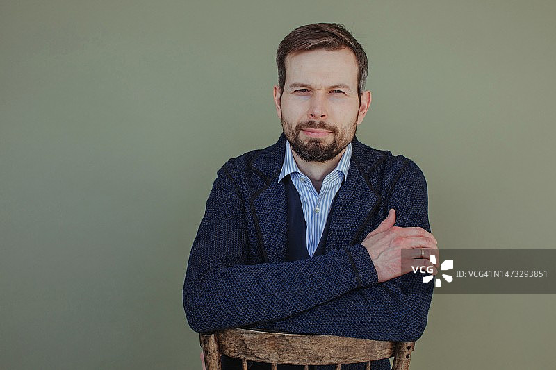 背靠椅子的英俊男子肖像图片素材