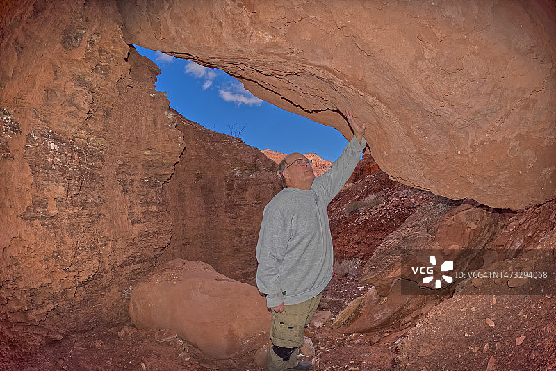 徒步者站在美国亚利桑那州格伦峡谷国家 recreation Area帕里亚峡谷的洞穴中图片素材