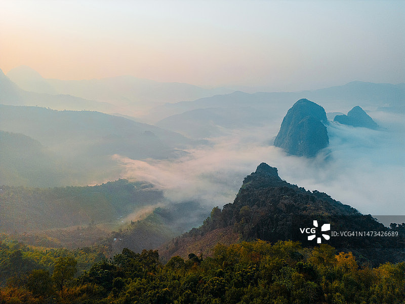 日出时云雾缭绕的喀斯特山脉航拍图片素材