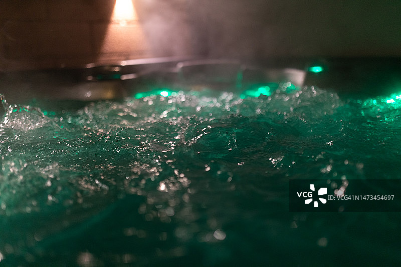 夜间带照明的温泉浴缸图片素材