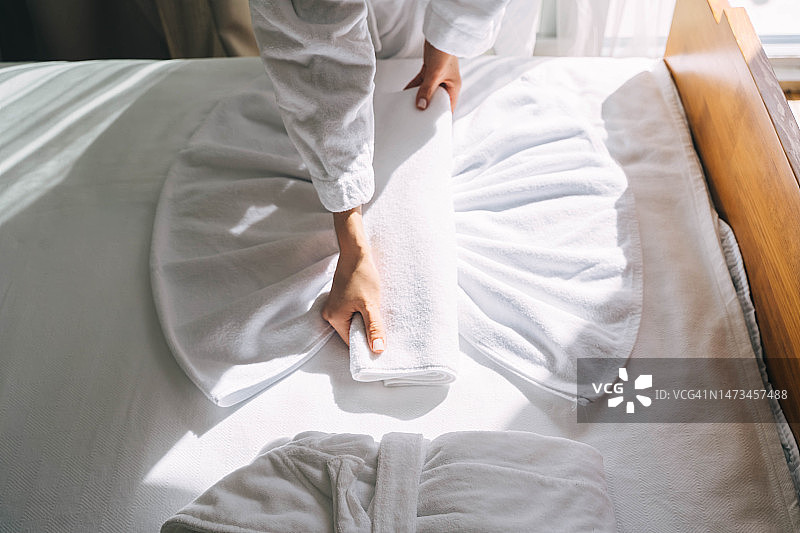女性在客人入住酒店前整理毛巾图片素材