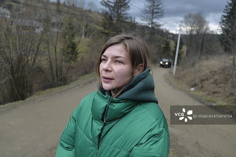 站在户外森林道路上的真诚的女人，沉思的女人图片素材