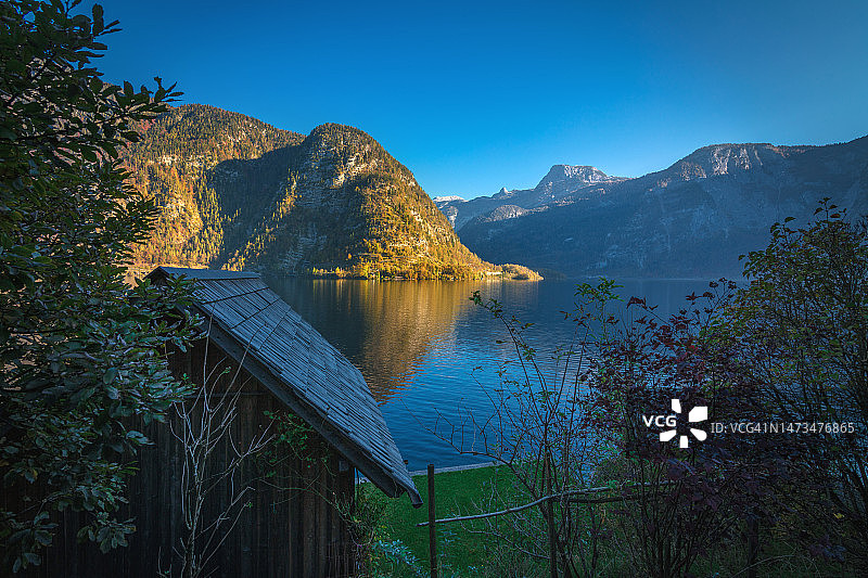 奥地利哈尔施塔特：日出时的木屋、山脉和湖泊图片素材