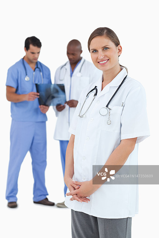 微笑的医生和同事，身后是X光片图片素材