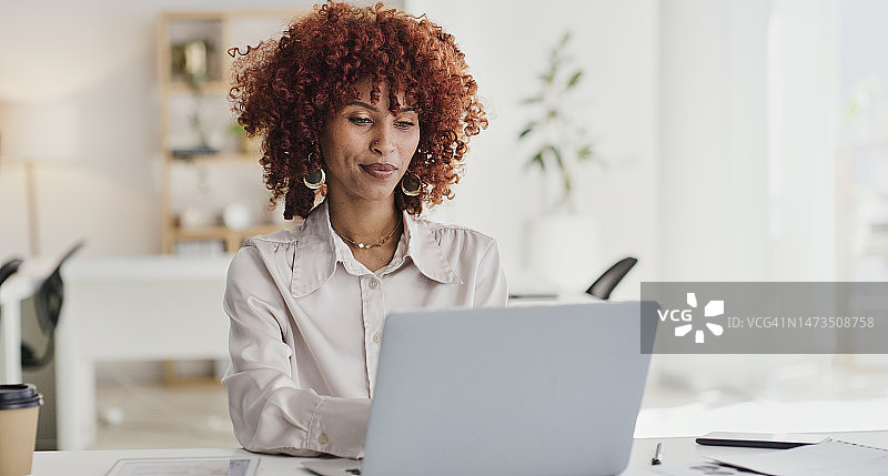 办公室里专注工作的黑人女性：使用笔记本电脑搜索项目方案，阅读邮件图片素材
