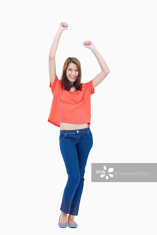 穿着休闲装，举起手臂的开怀大笑的少女图片素材
