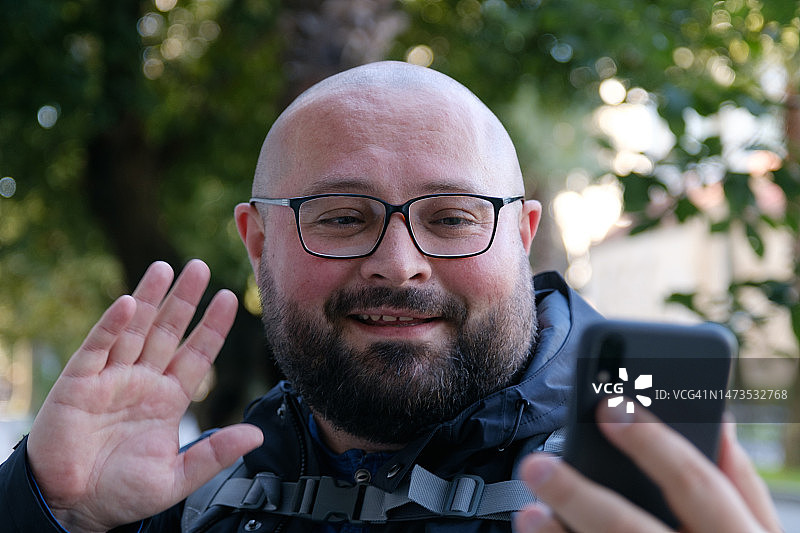 在欧洲城市街道上用手机进行视频通话的男人图片素材