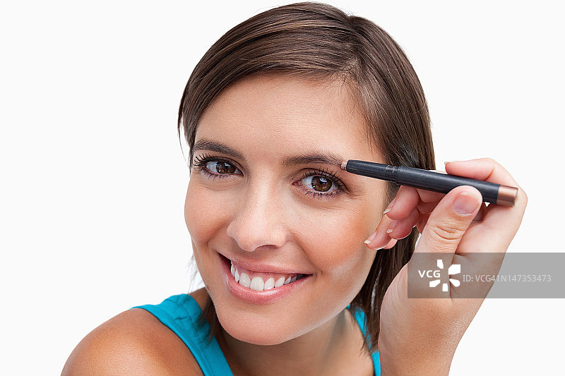 年轻女子用眉笔化妆图片素材