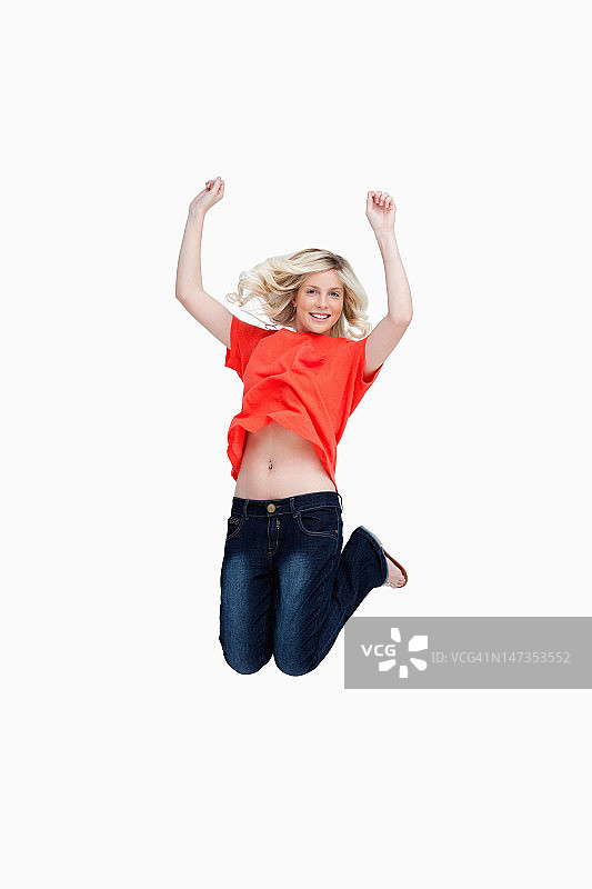 充满活力地跳跃并将手臂举过头顶的青少年图片素材