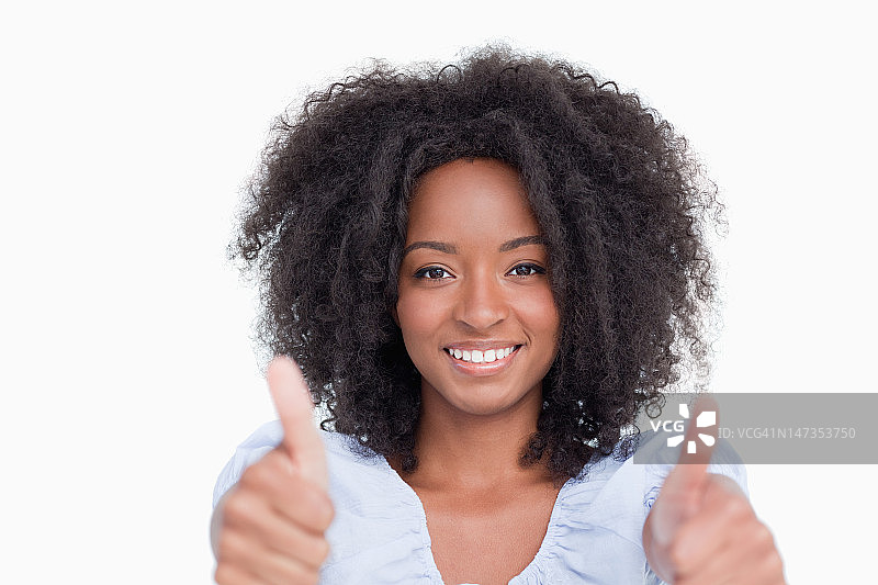 年轻女人满意地竖起两个大拇指图片素材