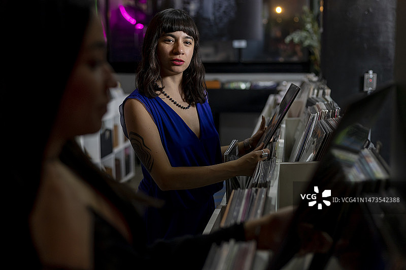 两个女孩在墨西哥城的一家商店里购买黑胶唱片图片素材