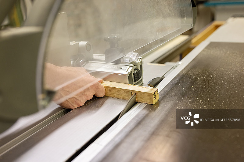 木匠在车间使用圆锯切割木材的特写图片素材