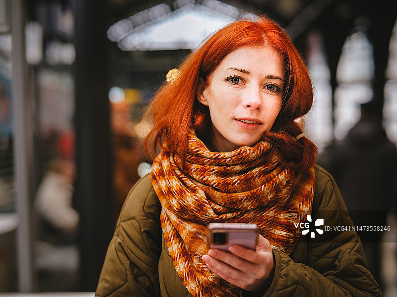 女子站在地铁站里使用手机图片素材