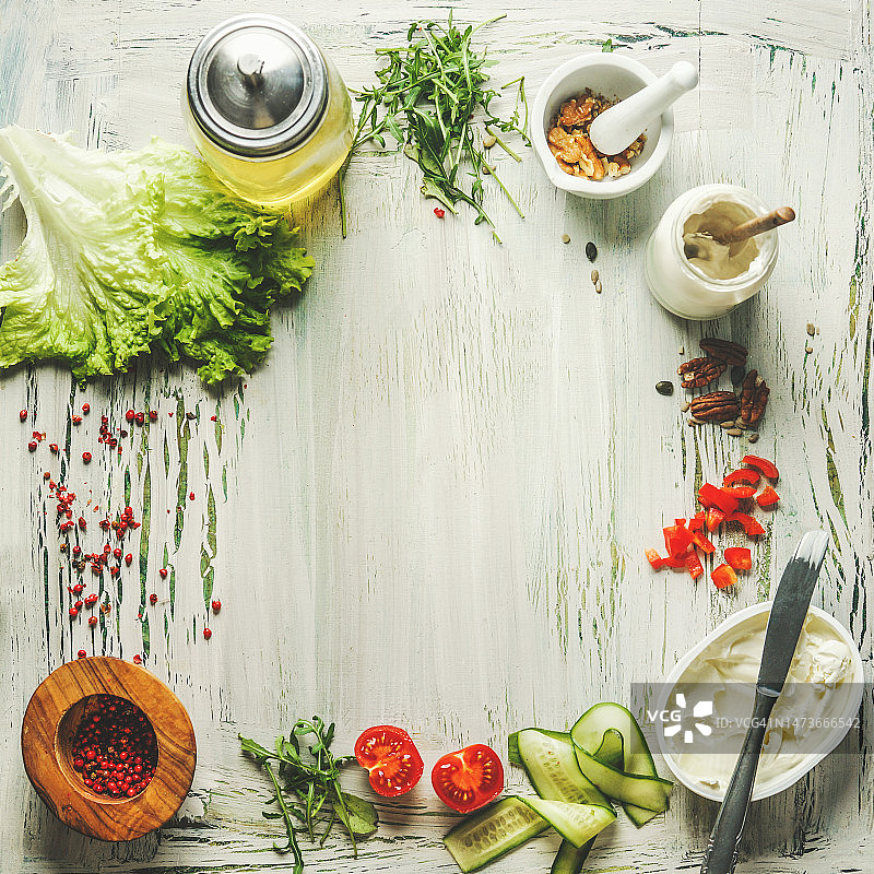 健康食品背景与沙拉配料：生菜、西红柿、黄瓜片、坚果、橄榄油和奶油奶酪图片素材