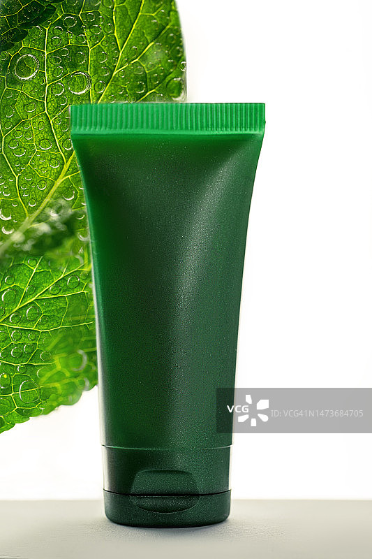 保湿面霜、护手霜、洗发水、发胶和薄荷叶在气泡水中特写图片素材