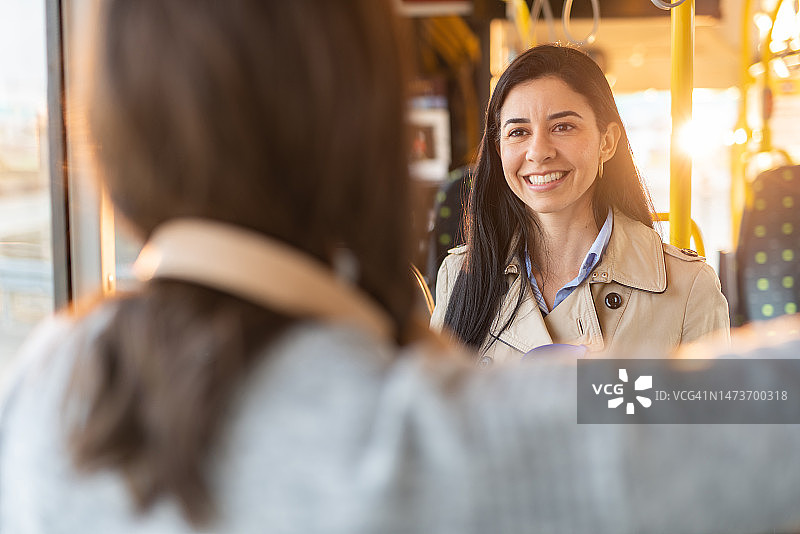 女性朋友在乘坐公共汽车时聊天图片素材
