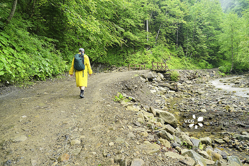 男子沿着河边的道路行走图片素材