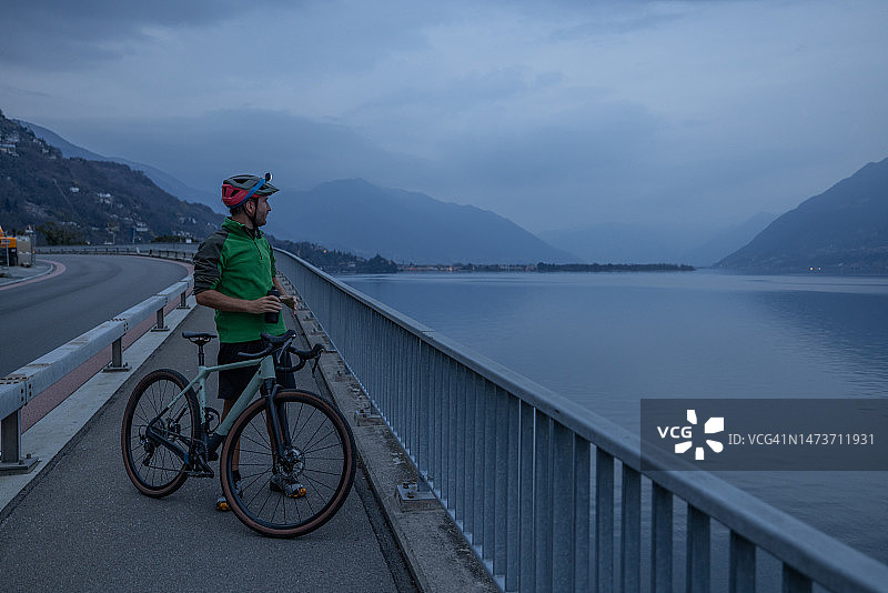 男子夜间训练骑行，在自行车道上休息图片素材
