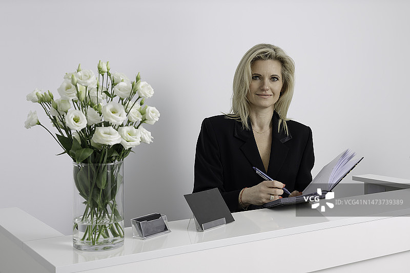 美丽的前台接待员在美容院预约图片素材