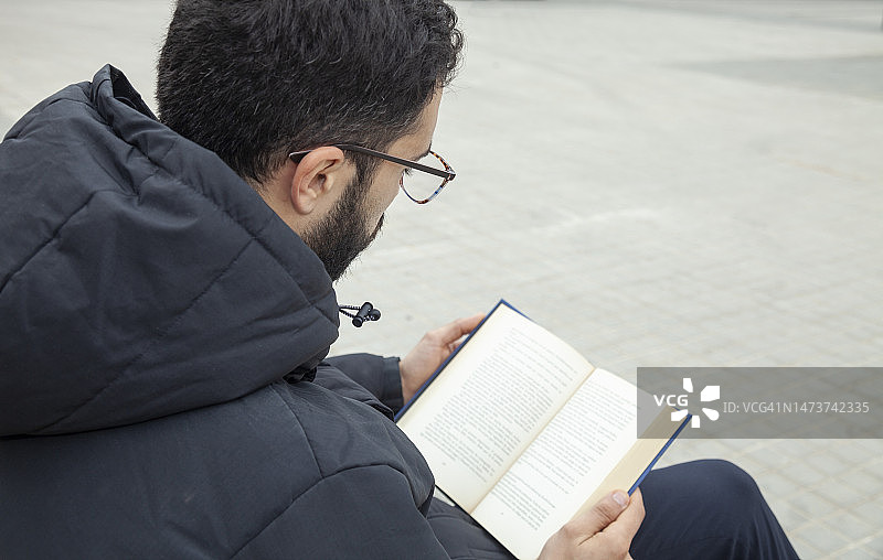 年轻男人在街上看书图片素材