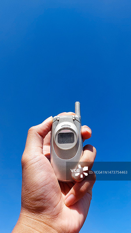 手持相机，以蓝天为背景图片素材