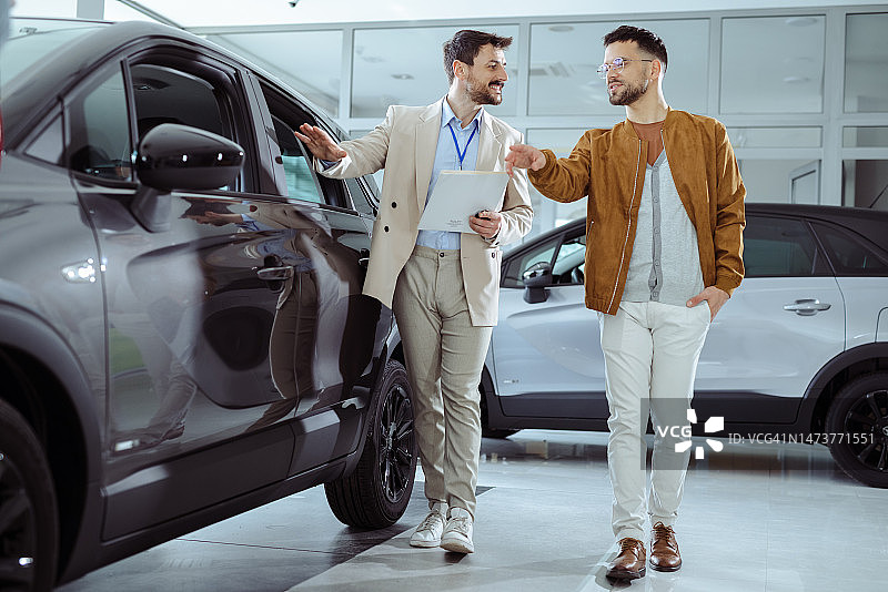 商人在展厅展示新款汽车模型图片素材