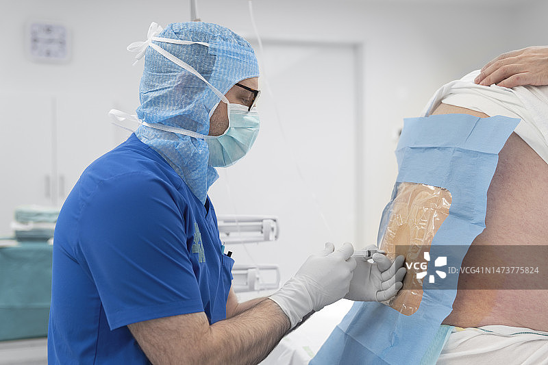 麻醉师在手术前为患者背部进行硬膜外麻醉图片素材