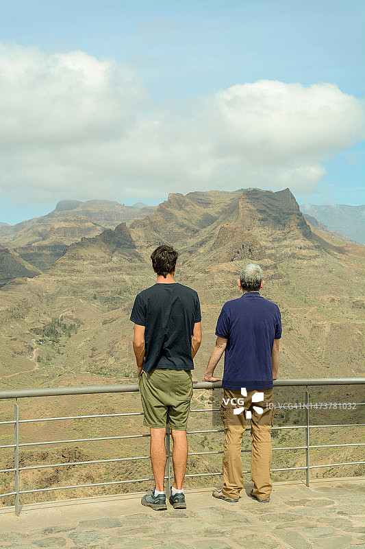 父亲和成年的儿子在思考干旱的景观图片素材