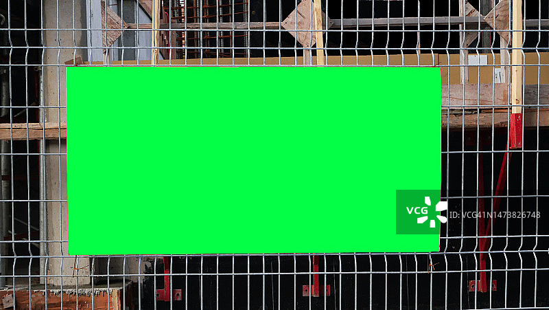 加拿大魁北克蒙特利尔建筑工地的金属防护网上空的绿色标志图片素材