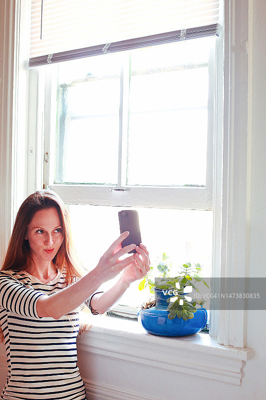 社交媒体营销推广，社交媒体达人，用智能手机直播的女人图片素材