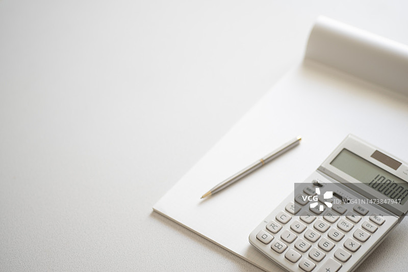 办公桌上的计算器和书写工具图片素材